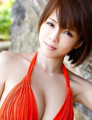 Japanese Yumiko Shaku  in orange bath suit takes a walk on the beach